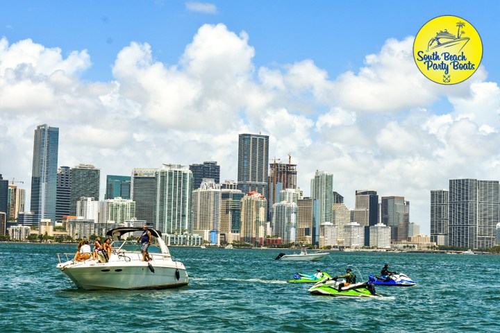 South Beach Party Boats a small boat and Jet Ski Rental in Biscayne Bay with city of Miami in the background.