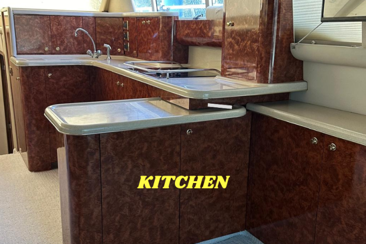 Luxurious yacht kitchen with wooden cabinets and modern appliances.