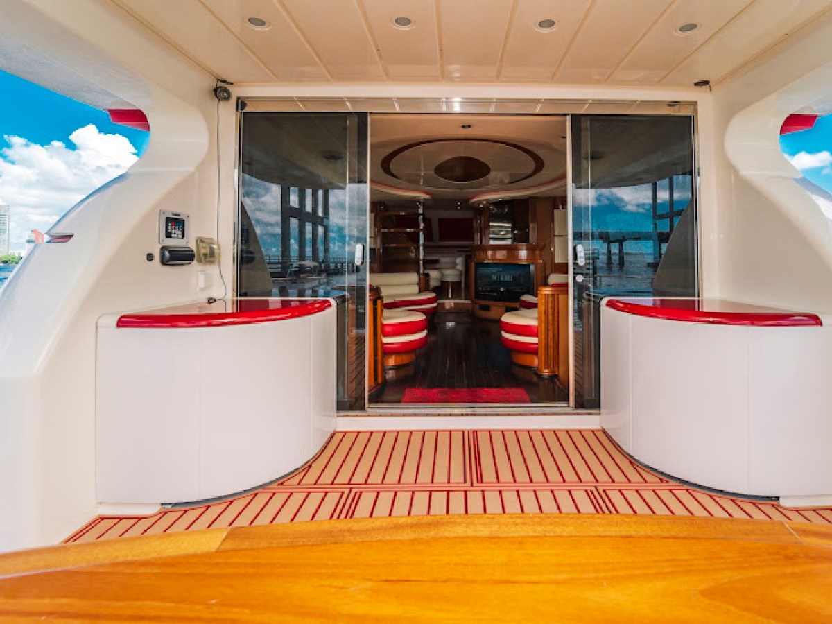 Luxury yacht interior with red and white seating and wood flooring.