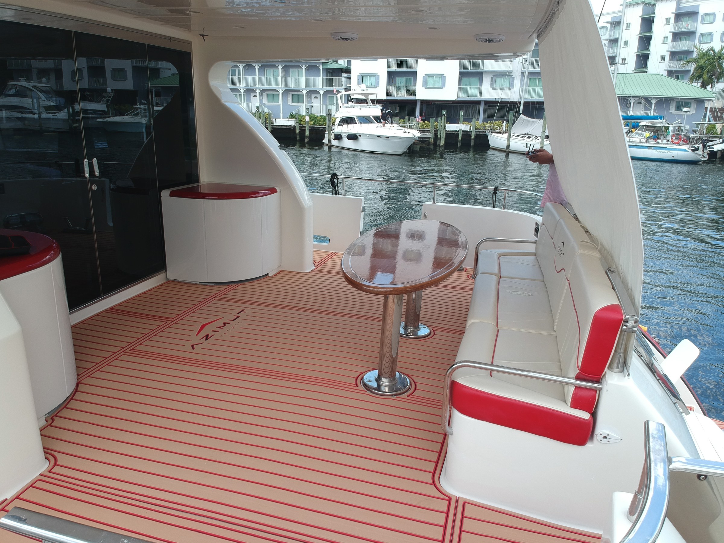 Boat deck with seating, table, and harbor view.