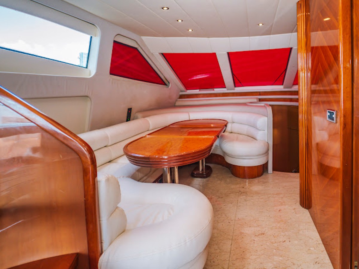 Luxurious yacht interior with white seating and red window covers.