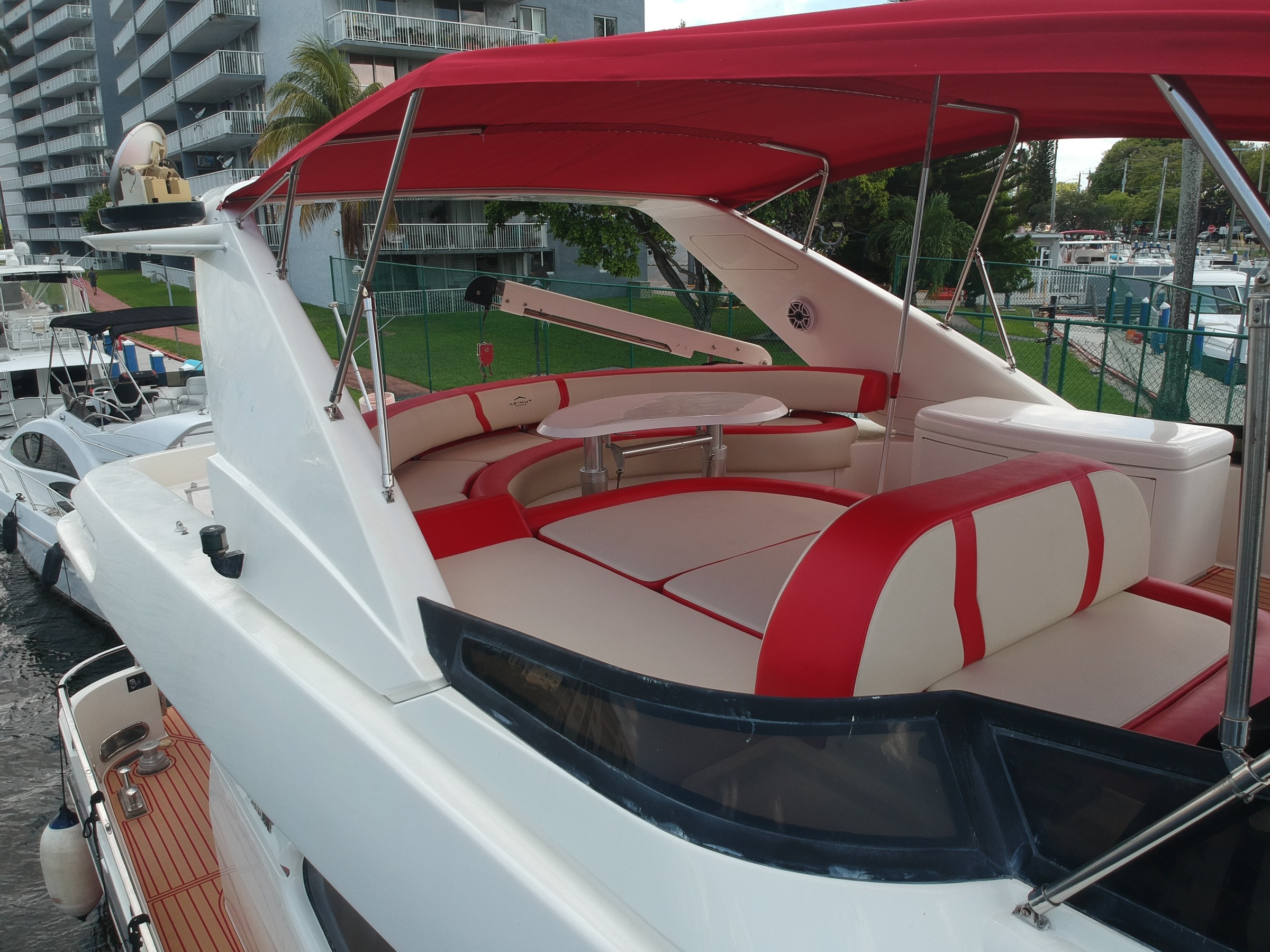 Red and white luxury boat deck with seating and canopy.